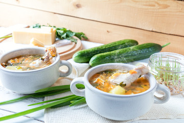 Cheese soup with chicken, herbs and vegetable. Cheese, cucumbers and herbs on wooden table. Light background