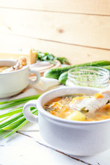 Cheese soup with chicken, herbs and vegetable. Cheese, cucumbers and herbs on wooden table. Light background