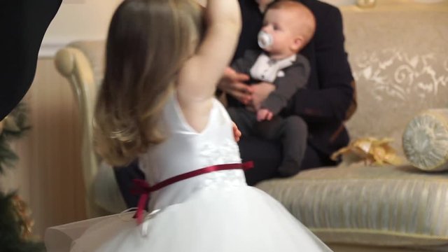 Close-up of a little girl dancing in front of her father sitting on the couch