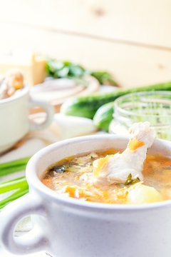 Cheese soup with chicken, herbs and vegetable. Cheese, cucumbers and herbs on wooden table. Light background