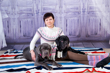 Attractive girl posing in the studio with puppies of breed Mastiff Neapolitana.