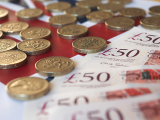 Pound coins and notes, United Kingdom over flag