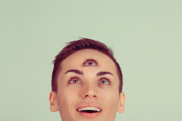 Happy Woman with 3 third eye looking up to copy space concentrating thinking with mind and heart...
