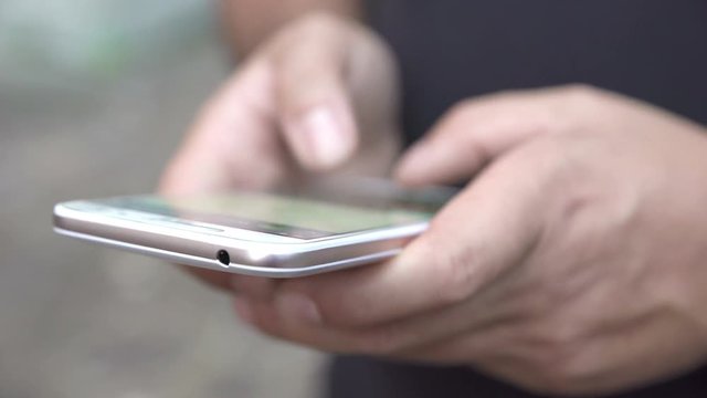 hands of young men who write on smartphone