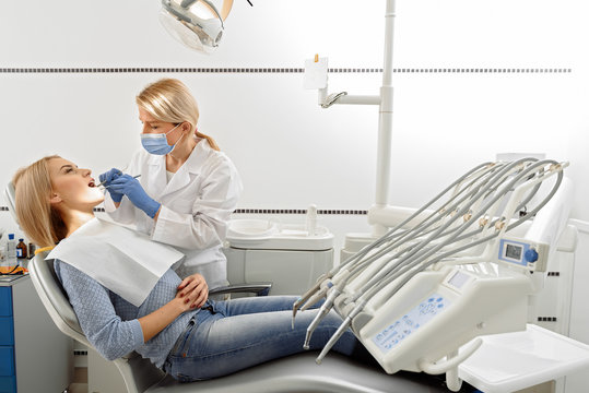 Dentist operating tools in oral cavity of patient