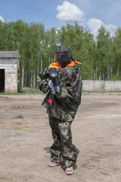 Paintball player in camouflage suits with paintball gun in hand lined up