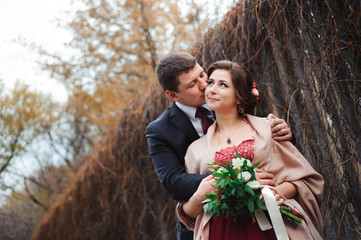 Portrait of happy newlyweds in autumn nature. Happy bride and gr