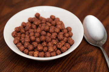 Chocolate corn balls in white plate and spoon