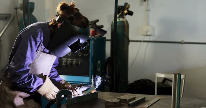 Female welder welding a metal