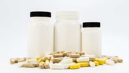 Jars of medicines under the pills lying on a white background