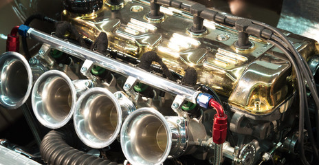 4 Zylinder Motor von Sportwagen mit goldenem Zylinderkopf und 4fach Vergaser