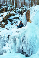 Portret young man sitting in meditation winter river