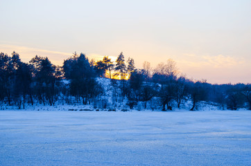 winter forest and the river at sunset