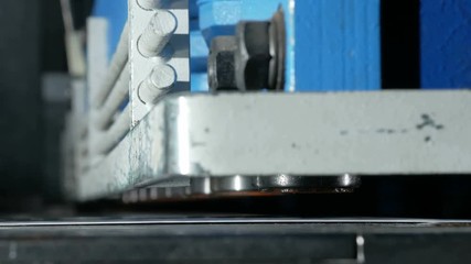 The machine cuts the sheet metal. Large hydraulic guillotine shears. Close-up. Detail pressed cylinders and cut off several times.