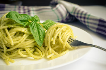 Italian pasta spaghetti with homemade pesto sauce and basil leaf