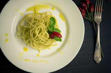Italian pasta spaghetti with homemade pesto sauce and basil leaf