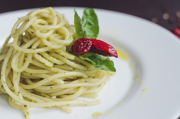 Italian pasta spaghetti with homemade pesto sauce and basil leaf