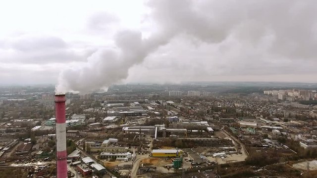 Aerial view of the industrial part of the city. Camera flying near the brick chimney of the heat power plant. 4K