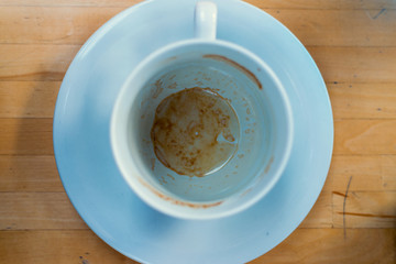 An empty coffee cup on the table and set on the ground