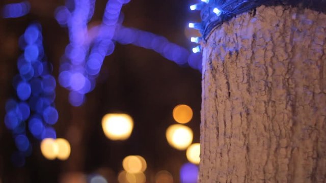 Christmas and New Year background. Abstract blurred bokeh. Blinking garland on a tree.
