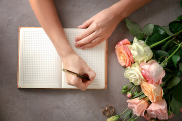 Female hands writing wedding to do list on table