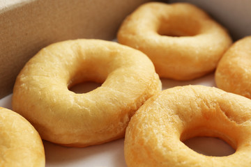 Delicious donuts in a cardboard box, closeup