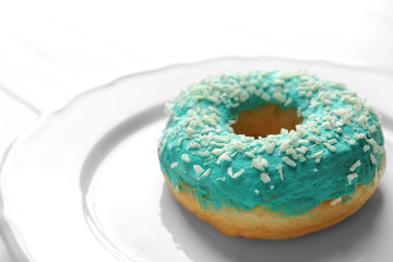 Delicious glazed donut on white plate, closeup