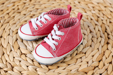 Cute baby shoes on wicker mat