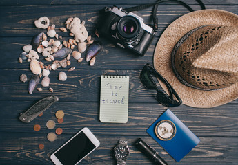 Travel background. Men's style clock, flashlight, documents, hat, compass, money, phone and camera on a wooden background