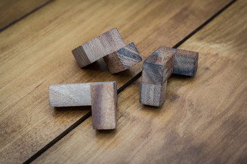 Wooden Block Brain Teaser on Wood Background Pieces Close Up