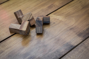 Fototapeta na wymiar Wooden Block Brain Teaser Puzzle on Wood Background Individual P