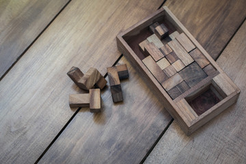 Wooden Block Brain Teaser Puzzle on Wood Background Top View