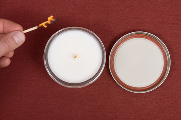 Soy candle in glass jar on red fabric background