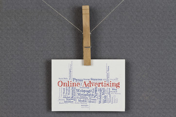 Online Advertising word cloud on a business card pinned up on a board