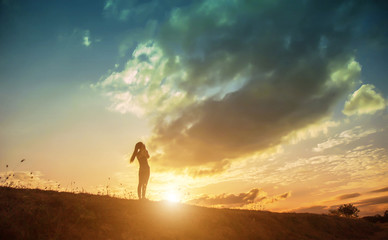 Fototapeta premium Silhouette of woman praying over beautiful sky background