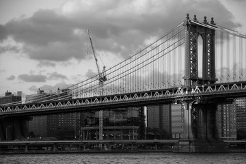 Fototapeta na wymiar Manhattan bridge over the river and the city in black and white style, New York