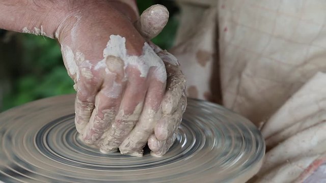 Man and woman makes a pot on pottery wheel. Hands of a potter and his apprentice. Man and woman hands. Woman is the pupil of a potter