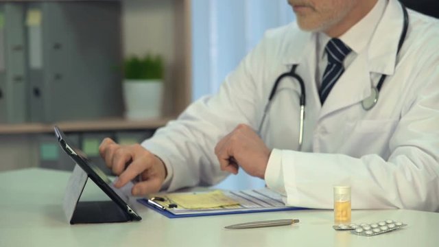 Physician looking at registration form, prescribing treatment online, consultant