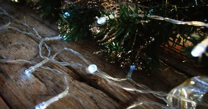 Wreath with christmas lights and decoration on a plank