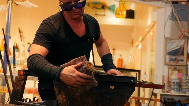 Glassblowers shaping a molten glass