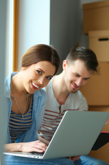 Young couple sitting on the floor of their new apartment