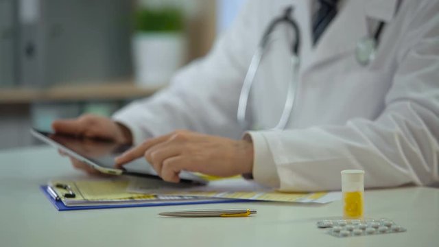 Head physician consulting patient online using tablet, modern technologies