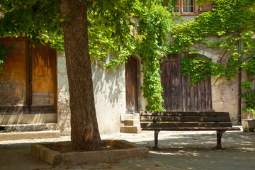 Obraz premium Park bench in a courtyard. Avignon Provence France.