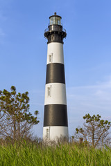 The historic Bodie Island Lighthouse rises over the coastal landscape of Cape Hatteras National...