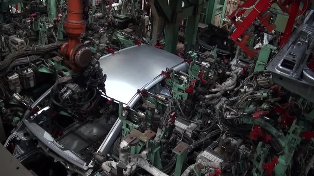 Timelaps Car factory. Robotic arm machine welding and joining pieces. Making car in working lines