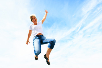 Obraz premium Woman In Her 50s Jumping High Into The Sky