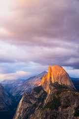 Half Dome Rock Yosemite National Park at Sunset.  Golden hour yellow sky and clouds.