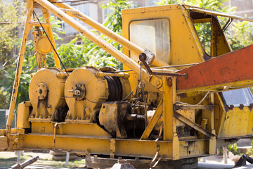 old, yellow hydraulic crane on the street