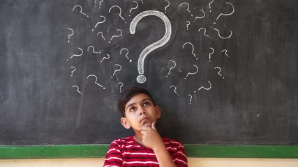 Concepts on blackboard at school. Young people, quiet student and pupil in classroom. Hispanic boy with doubts and thoughts in class. Portrait of male child thinking