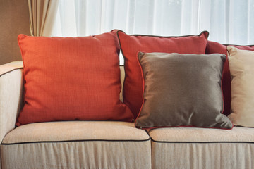 Red and deep brown linen pillows on beige linen sofa in modern classic living room